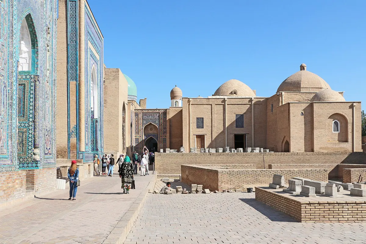 The tiled facades of mausoleums along the street of the Shah-i-Zinda necropolis in Samarkand under a blue sky