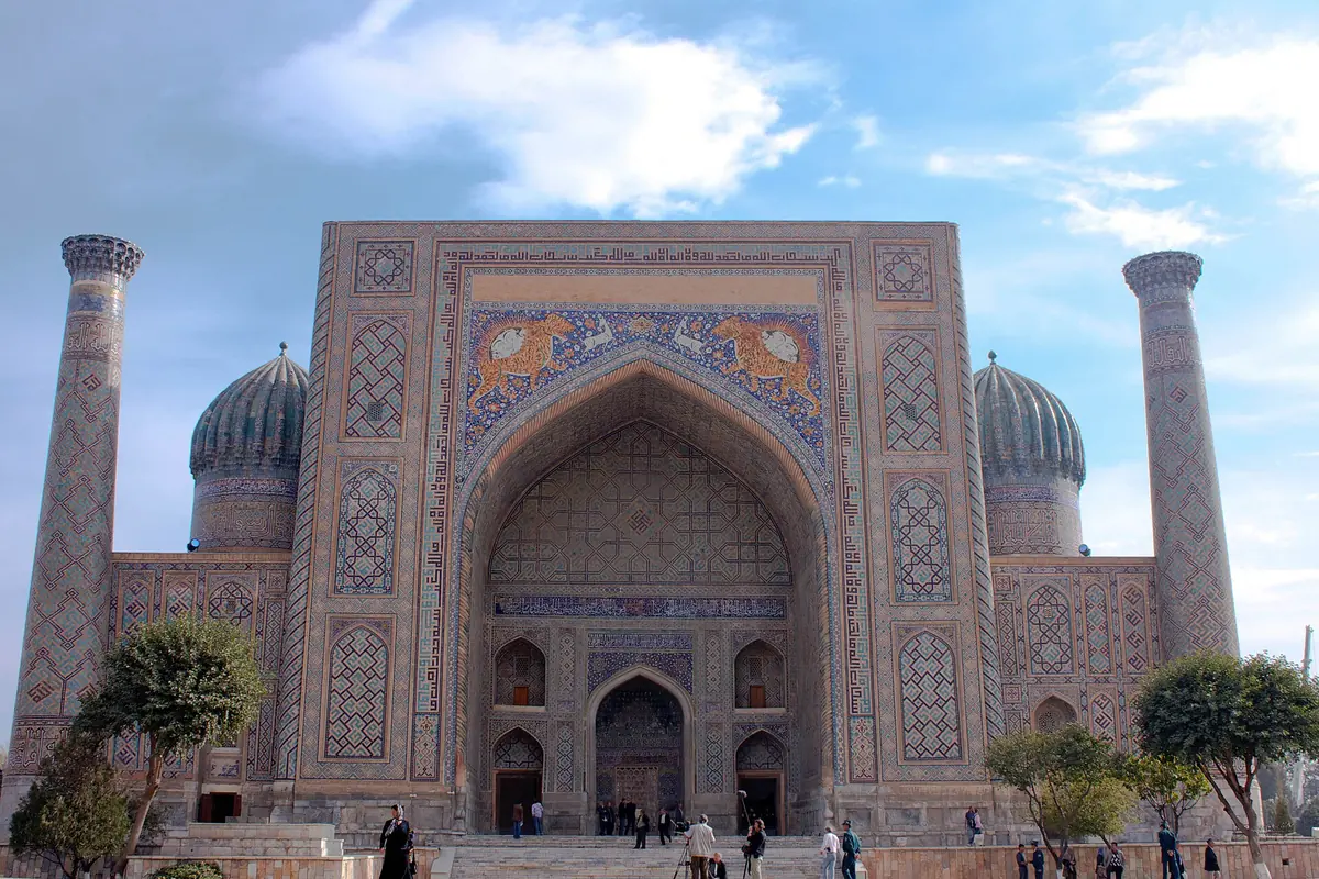 The Sherdar Madrasa on Registan Square in Samarkand, with its tall pointed portal, two ribbed blue domes and two minarets