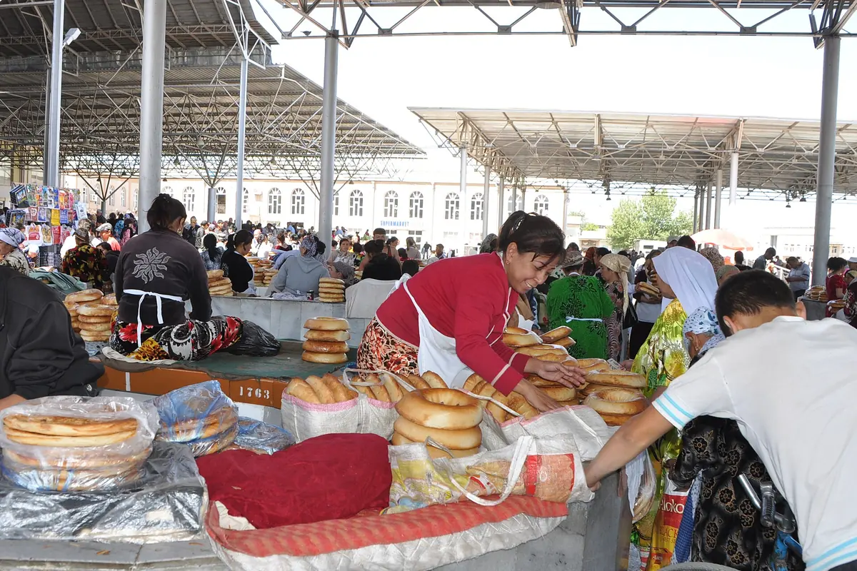 Stalls piled with round Uzbek bread under a covered market roof in the Siyob Bazaar in Samarkand